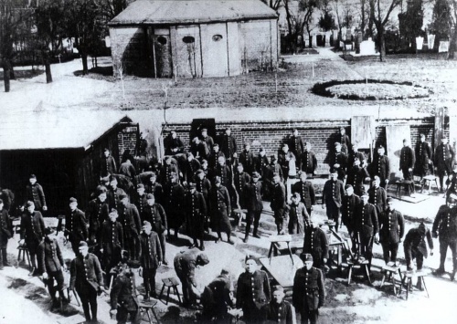 Fotografia żołnierzy z koszar zbudowanych w pobliżu kirkutu. W tle widoczny fragment cmentarza i zachowany do dzisiaj dom przedpogrzebowy. (fot. sprzed 1939 r. z archiwum Muzeum Okręgowego w Lesznie), zdjęcie nr 3