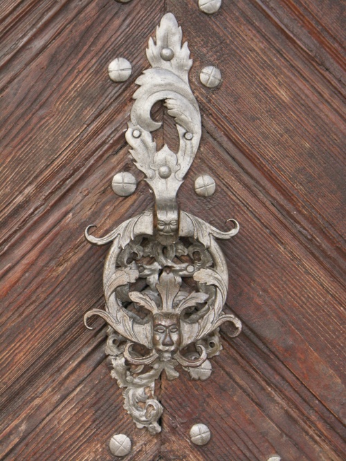 Kołatka na drzwiach dawnej pastorówki na pl. dra J. Metziga w Lesznie (ob. Muzeum Okręgowe). Arcydzieło sztuki kowalskiej z pocz. XVIII w. (fot. M. Urban. 2016 r.)